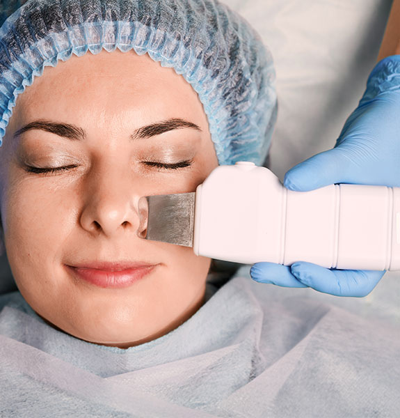 Chica haciéndose un tratamiento de limpieza profunda con punta de diamate en el rostro.